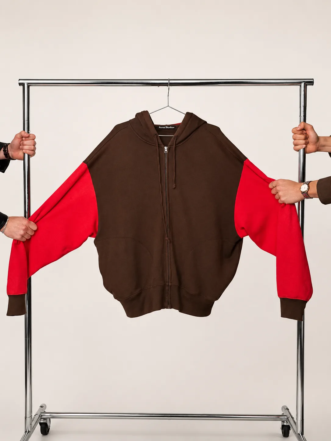 Hands passing a hoodie across a rack during a Ragpiq handoff